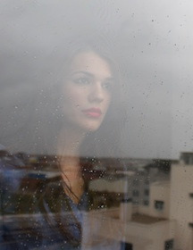 Woman looking out of window contemplating
