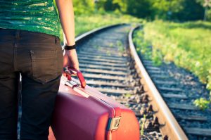 person-with-suitcase-waits-for-train-e1477411223771-300x199