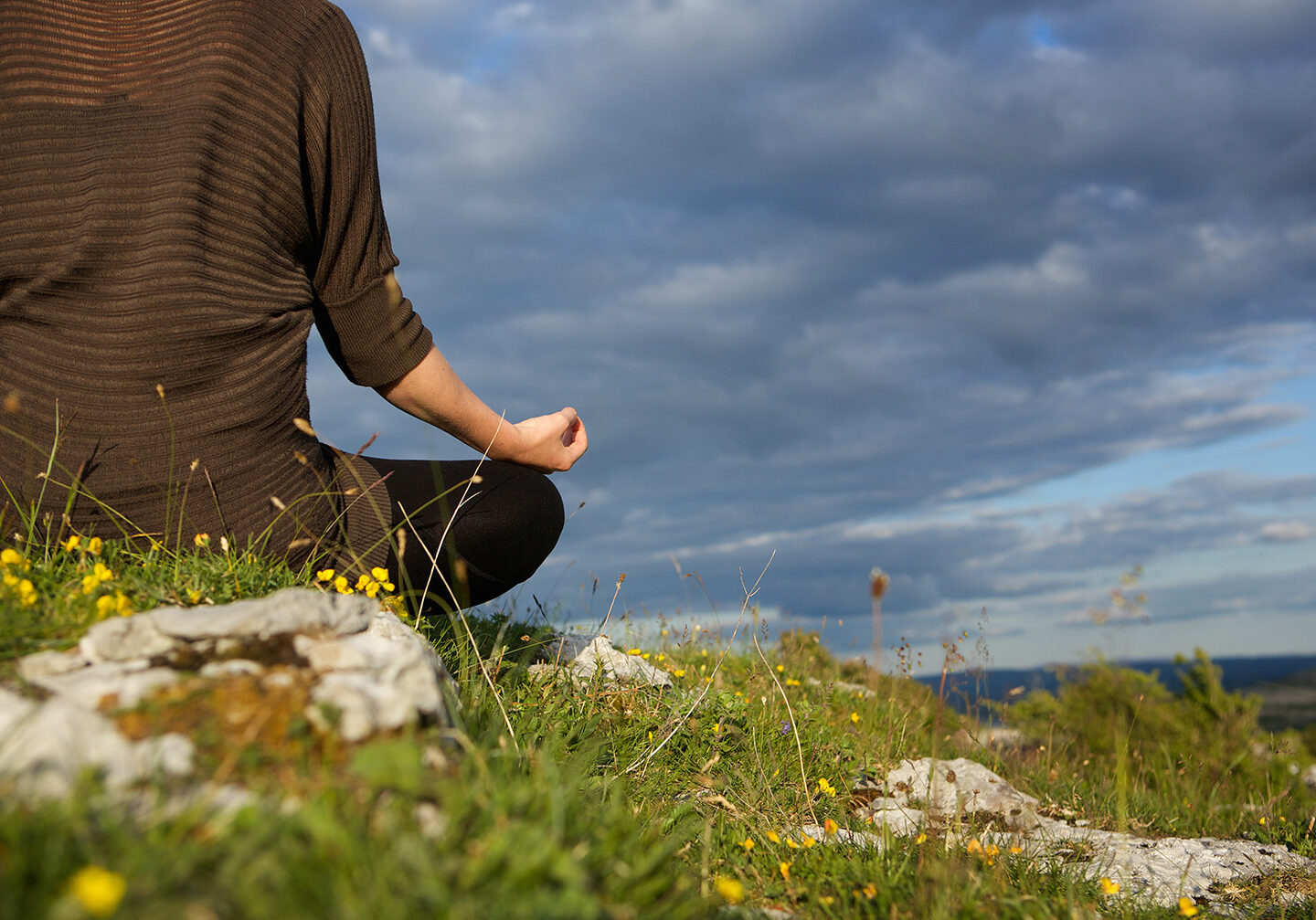 Young woman meditating in yoga position outdoors